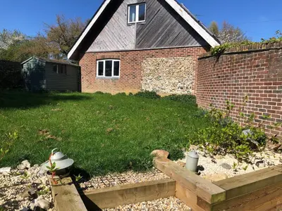 a backyard with a brick house and a fence at Cherry Trees in Stowmarket