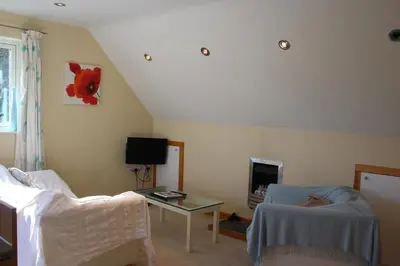 a living room with a couch and a table at Cherry Trees in Stowmarket
