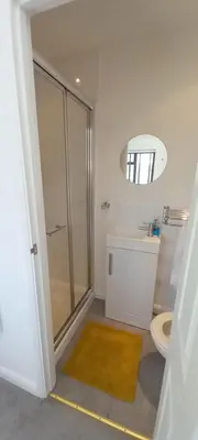 a bathroom with a shower and a sink and a toilet at Barn Farm Guest House in Cold Norton