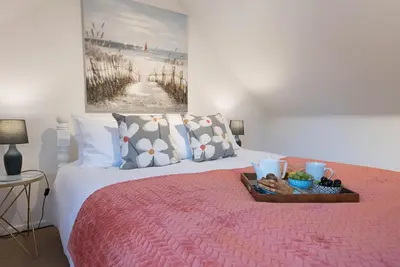 a bedroom with a bed with a tray of food on it at The Spinney Saxtead nr Framlingham in Woodbridge