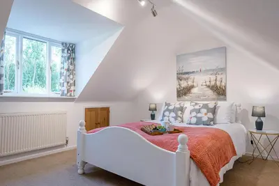 a bedroom with a white bed in a attic at The Spinney Saxtead nr Framlingham in Woodbridge