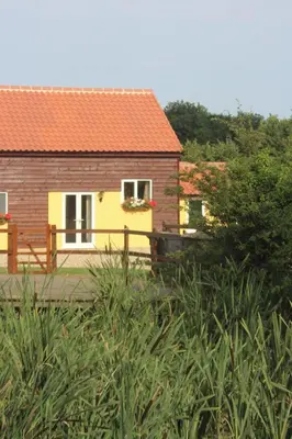 a house with an orange roof and a fence at Little Oaks in Stowmarket