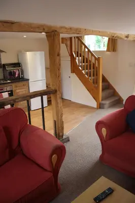a living room with two couches and a staircase at Little Oaks in Stowmarket
