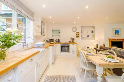 a kitchen with a table and a dining room at Theberton Cottage in Theberton
