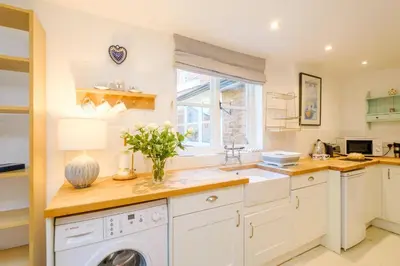 a kitchen with a washing machine and a window at Theberton Cottage in Theberton