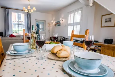 a dining room table with wine glasses and bread at Longshore, Aldeburgh in Aldeburgh
