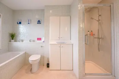 a white bathroom with a toilet and a shower at Longshore, Aldeburgh in Aldeburgh
