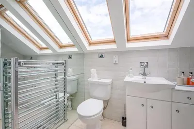 a bathroom with a toilet and a sink and skylight at Longshore, Aldeburgh in Aldeburgh