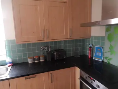 a kitchen with wooden cabinets and a black counter top at Science Park Suite in Cambridge