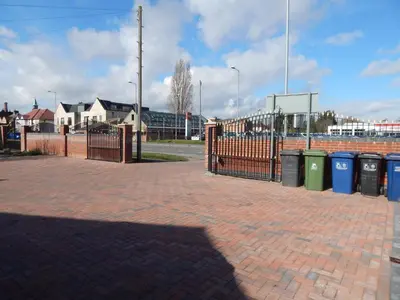 a brick sidewalk with trash cans and a fence at Science Park Suite in Cambridge