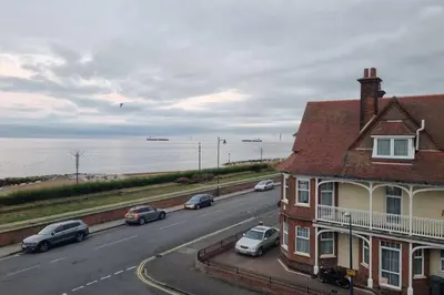 a road with cars parked on the side of a house at 2 Bedroom Seafront Apartment in Felixstowe