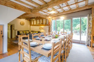 a dining room with a long table and chairs at Old Hall Barn - Aldeburgh Coastal Cottages in Darsham