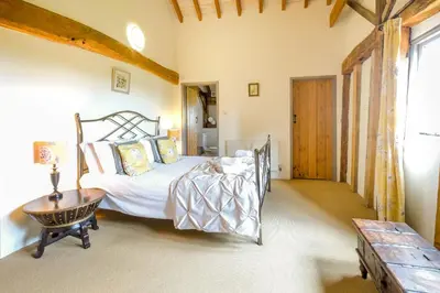 a bedroom with a bed and a table at Old Hall Barn - Aldeburgh Coastal Cottages in Darsham