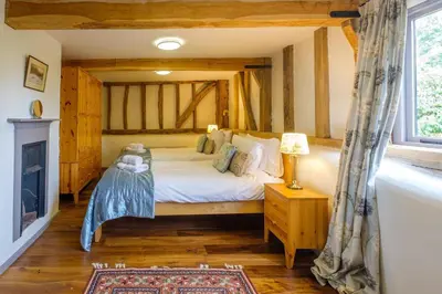 a bedroom with a bed and a fireplace at Old Hall Barn - Aldeburgh Coastal Cottages in Darsham