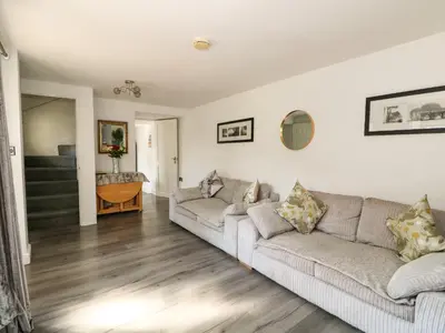 a living room with two couches and a staircase at Chalk Cottage in Thetford