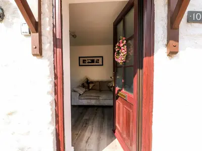 a door leading into a living room with a couch at Chalk Cottage in Thetford