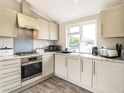 a white kitchen with white cabinets and a window at Lodge 47 in Ipswich