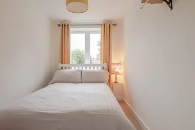 a bed in a room with a window at Lovely Central Cambridge Home in Cambridge