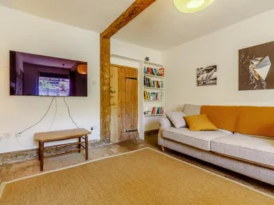 a living room with a couch and a tv at Angel Lane in Woodbridge