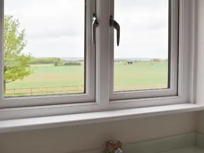 a window with a view of a green field at Leveret Lodge in Burgh
