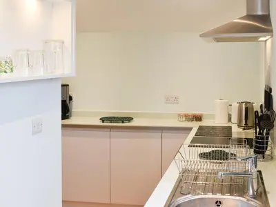 a white kitchen with a sink and a stove at Leveret Lodge in Burgh