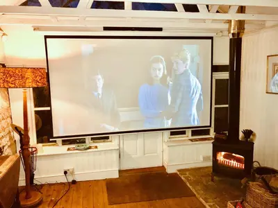 a large screen in a living room with a tv at Lavender Cottage in Methwold