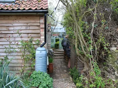 a small house with a water tank next to a building at Lavender Cottage in Methwold