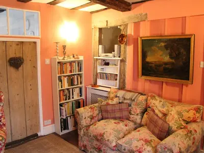 a living room with a couch and a book shelf at Lavender Cottage in Methwold