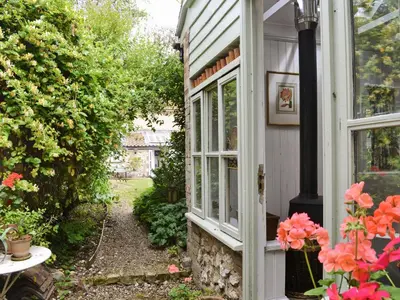 a door to a house with a window and flowers at Lavender Cottage in Methwold