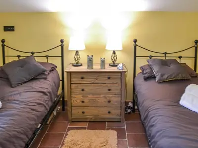 two beds sitting next to each other in a bedroom at Bradcar Farm Cottage in Snetterton