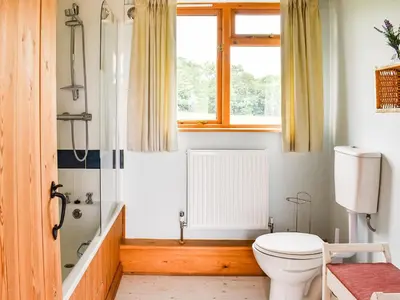 a bathroom with a toilet and a window at The Long Barn in Chelmsford