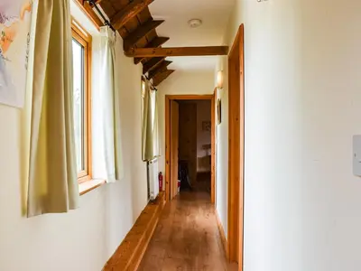a hallway in a house with windows and wooden floors at The Long Barn in Chelmsford