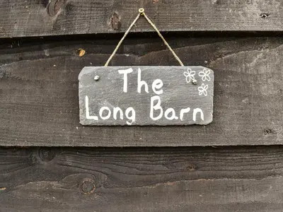 a sign that says the long barn hanging on a wooden door at The Long Barn in Chelmsford