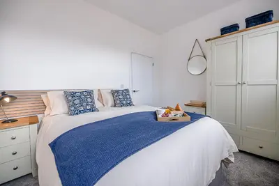 a bedroom with a large bed with a blue blanket at The Art Room, Leiston in Leiston