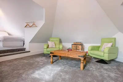 a room with two chairs and a table and a bed at The Art Room, Leiston in Leiston