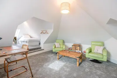 a attic room with a bed and two chairs and a table at The Art Room, Leiston in Leiston