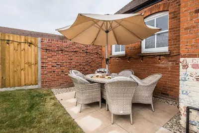 a table and chairs with an umbrella on a patio at The Art Room, Leiston in Leiston