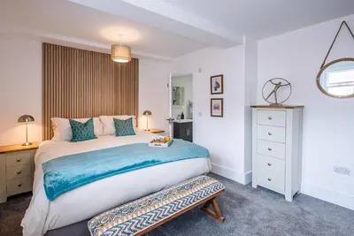 a bedroom with a large bed and a mirror at The Art Room, Leiston in Leiston