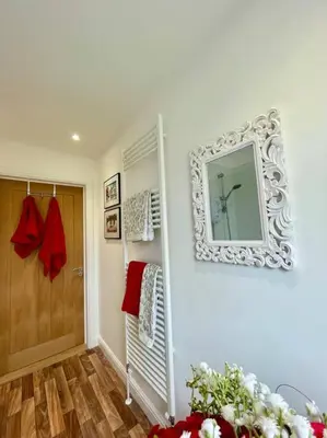 a bathroom with a mirror on the wall and a door at Stylish Boutique Bungalow in Felixstowe