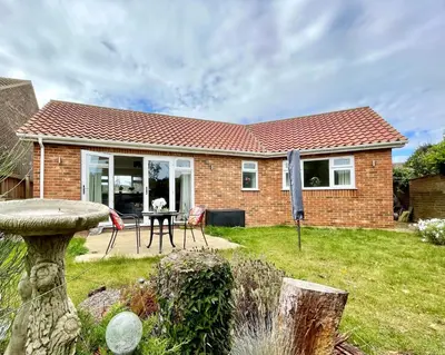 a brick house with a table and chairs in a yard at Stylish Boutique Bungalow in Felixstowe
