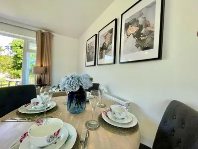 a dining room table with plates and glasses on it at Stylish Boutique Bungalow in Felixstowe