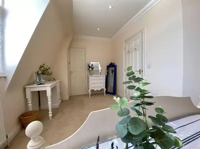 a white room with a staircase and a table and a plant at Coastal Mews House close to Beach in Felixstowe