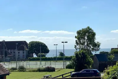 a car parked in a parking lot with a tennis court at Coastal Mews House close to Beach in Felixstowe
