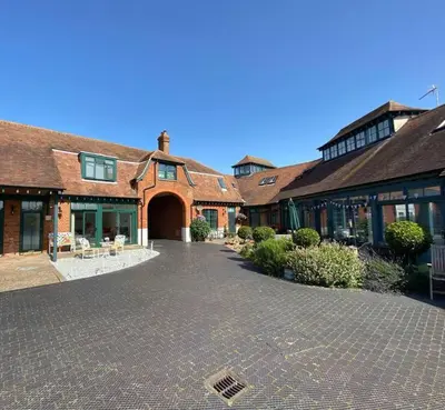 a large brick building with a driveway in front of it at Coastal Mews House close to Beach in Felixstowe