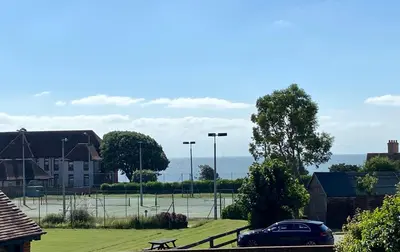 a car parked in front of a tennis court at Coastal Mews House close to Beach in Felixstowe