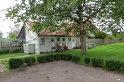a white house with a tree in the yard at The Old Stables, Whitehall Farmhouse, Oakington in Cambridge