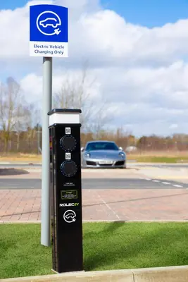 a parking meter sitting in the grass next to a street at Holiday Inn Express Cambridge West - Cambourne by IHG in Cambridge