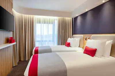 a hotel room with two beds and a television at Holiday Inn Express Cambridge West - Cambourne by IHG in Cambridge