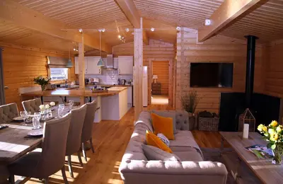 a living room with a couch and a table at Cambridgeshire Lakes - luxury lodges in a stunning lake location in Gamlingay