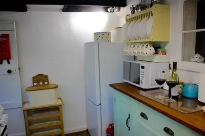 a kitchen with a refrigerator and a bottle of wine at Romantic* Castle on the Hill Cottage *Framlingham in Framlingham